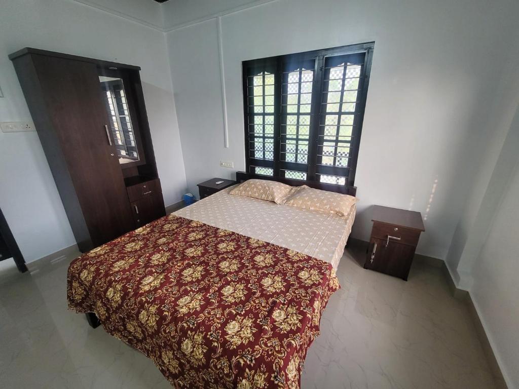 a bedroom with a bed and two windows at Private Room! Alleppey Villa! in Alleppey