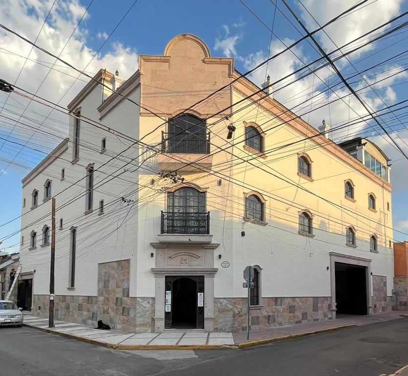 un grand bâtiment blanc au coin d'une rue dans l'établissement HOTEL CASA DE LAS PALOMAS, à Tonalá