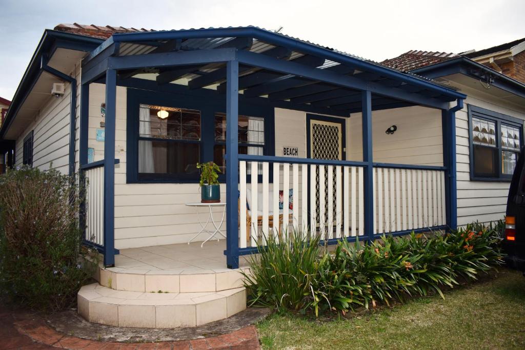 Wollongong Beach House Living في Gwynneville: بريغولا زرقاء على واجهة المنزل