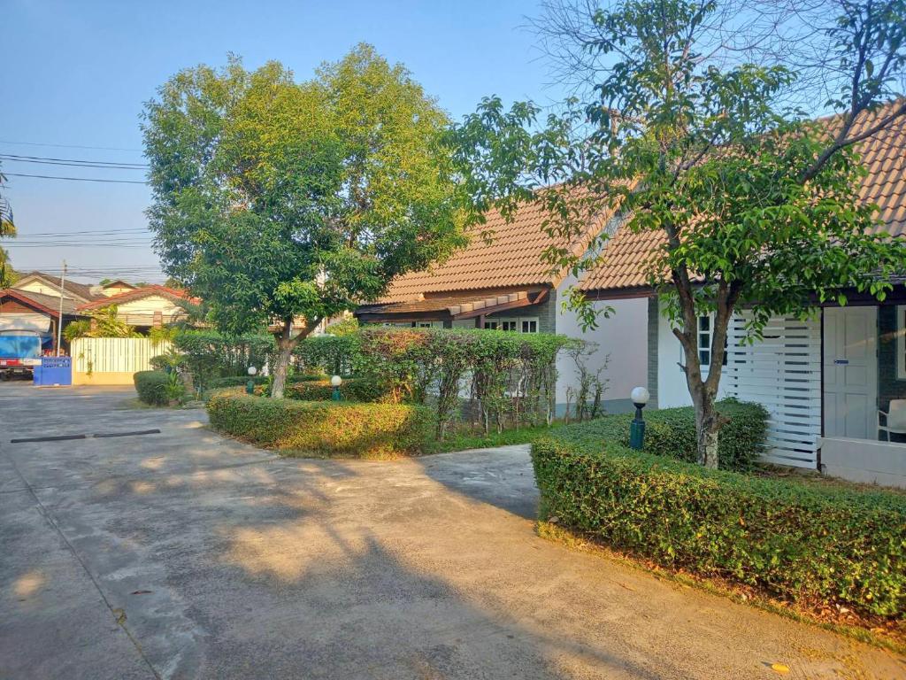 Ban Na Khwai的住宿－Dusita Parkview Resort @ Khua Suan Pla，一座有树木的房子,前面有一条街道