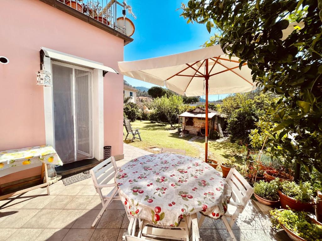 een tafel en stoelen met een parasol op een patio bij Casa Fiori D'Arancio in Levanto