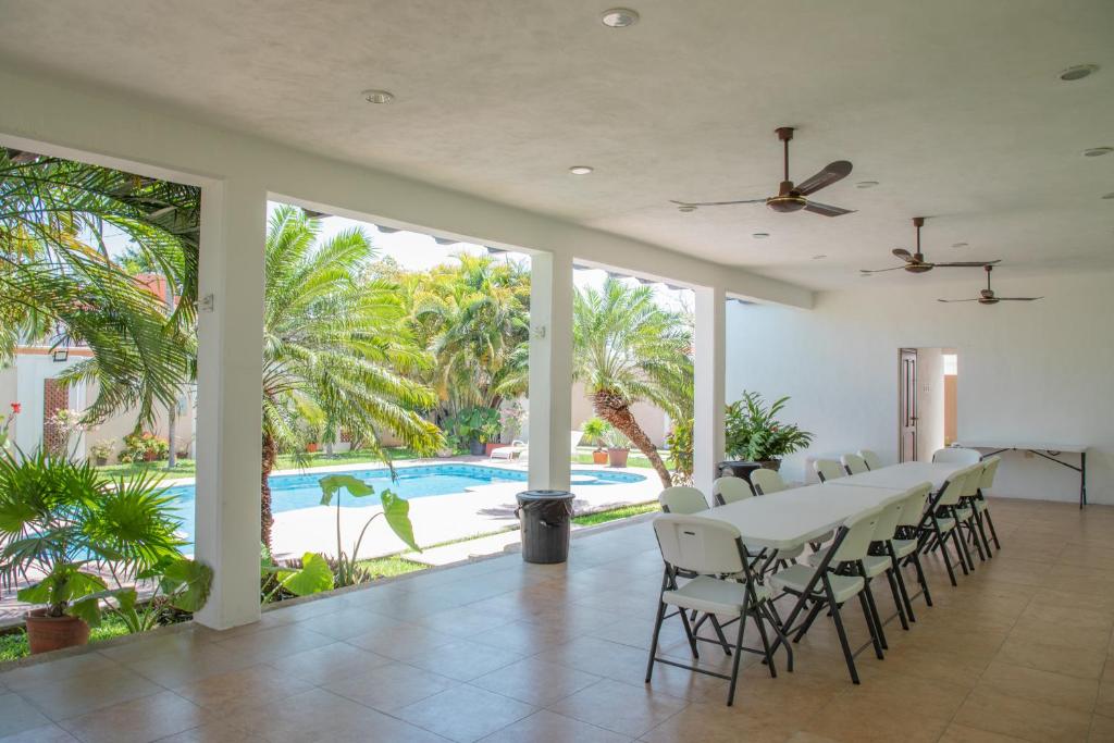 a dining room with a table and chairs and a pool at Casa privada con alberca grande in Chetumal