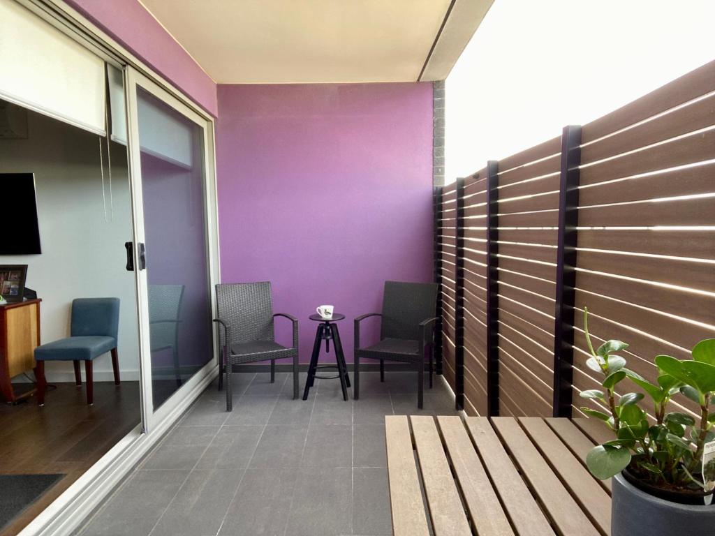 Un balcón con sillas y una pared púrpura. en Beach Life en Aspendale