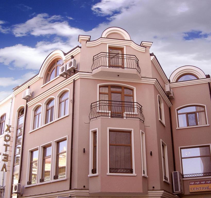 a large pink building with windows and balconies at Central Family Hotel in Haskovo