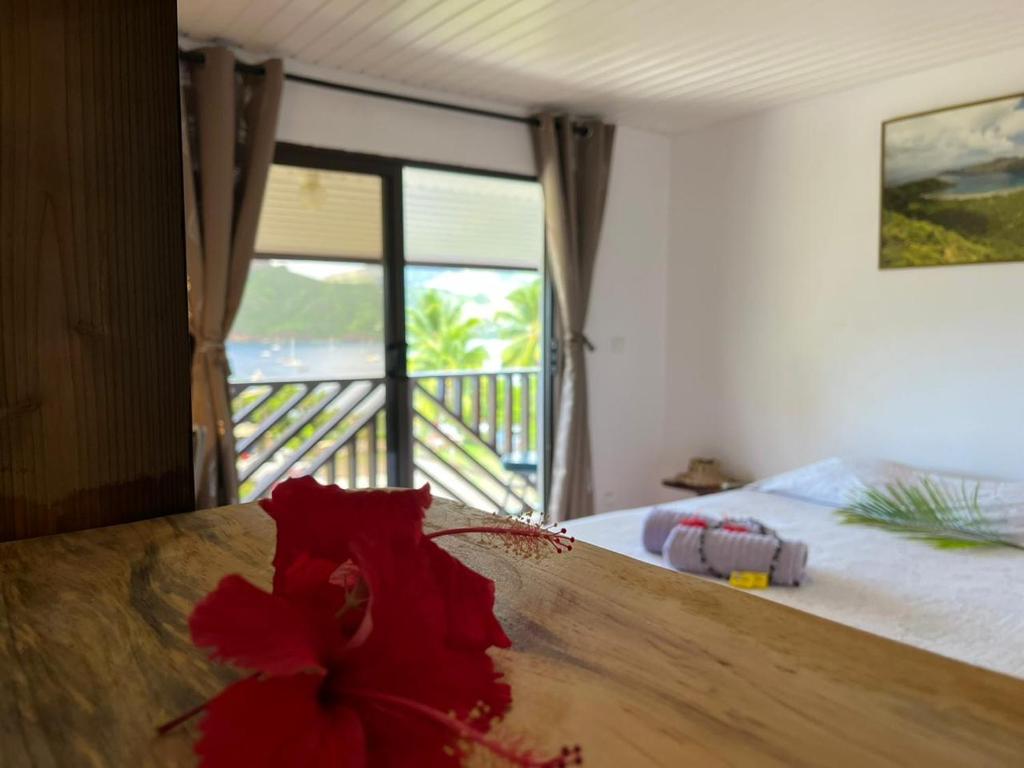ein Schlafzimmer mit einem Bett mit einer roten Blume darauf in der Unterkunft Pension Mave Mai in Nuku Hiva