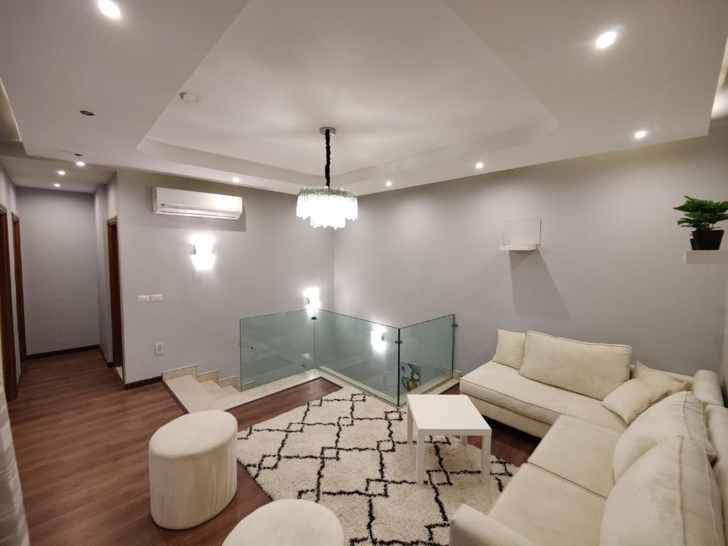 ein Wohnzimmer mit einem Sofa und einem Glastisch in der Unterkunft Luxury Duplexe in Beverly Hills in Sheikh Zayed