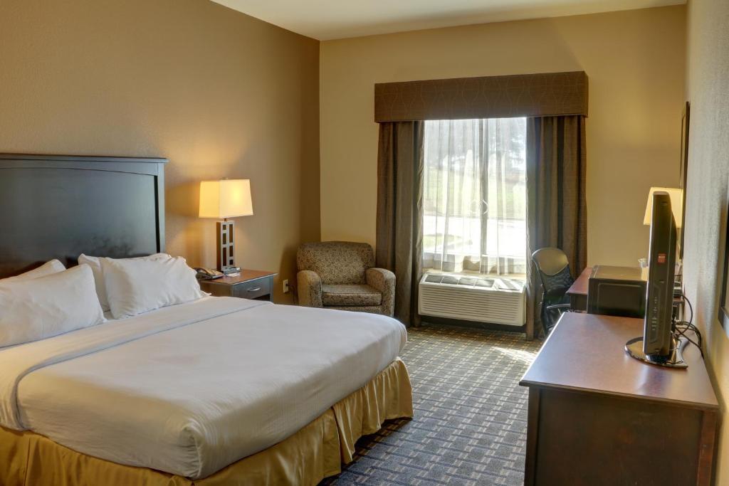 a hotel room with a large bed and a window at Holiday Inn Express Hotel & Suites Texarkana East by IHG in Texarkana