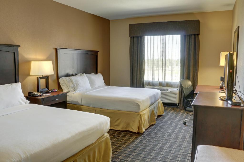 a hotel room with two beds and a television at Holiday Inn Express Hotel & Suites Texarkana East by IHG in Texarkana