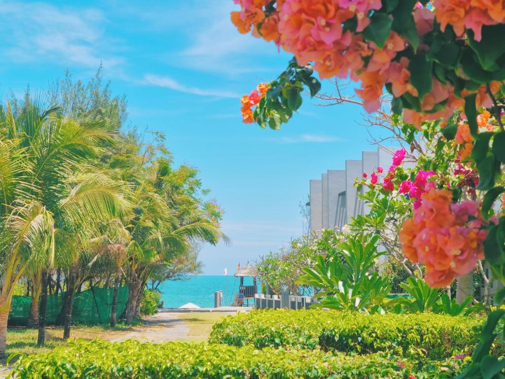 uma vista para uma praia com palmeiras e para o oceano em Oceanami Resort Sea View em Long Hai