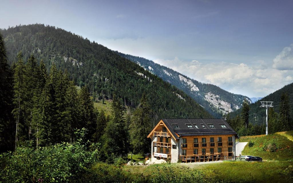 a house on the side of a hill with a mountain at Apartmany Demänovka in Demanovska Dolina