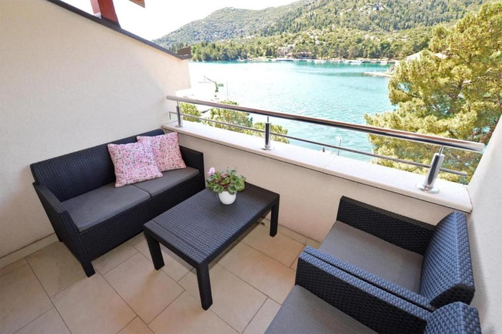 d'un balcon avec un canapé et une table offrant une vue sur l'eau. dans l'établissement Apartment Leo - sea view & comfortable, à Ploče