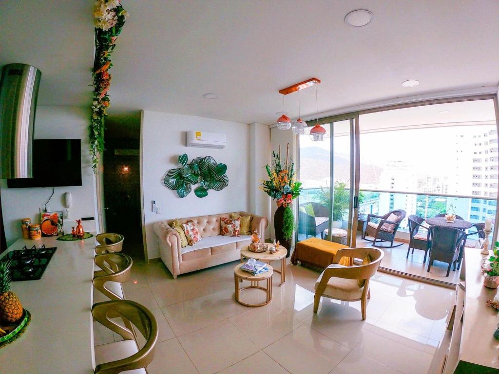 Apartamento en santa marta pozos colorados Samaria club de playa في سانتا مارتا: غرفة معيشة مع أريكة وكراسي