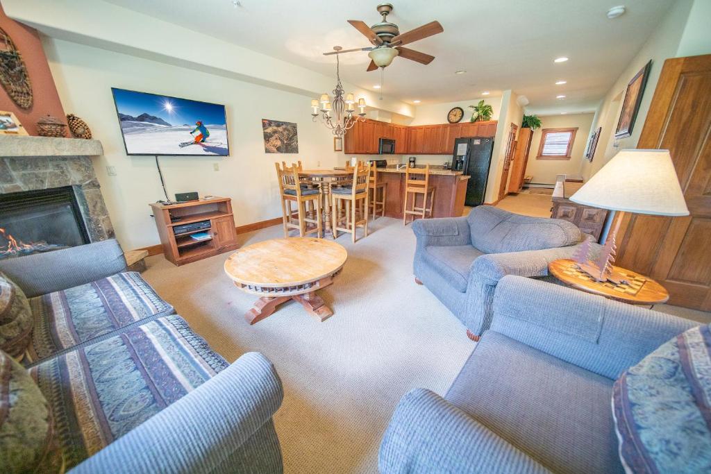 uma sala de estar com sofás azuis e uma lareira em Red Hawk Townhomes 2352 em Keystone