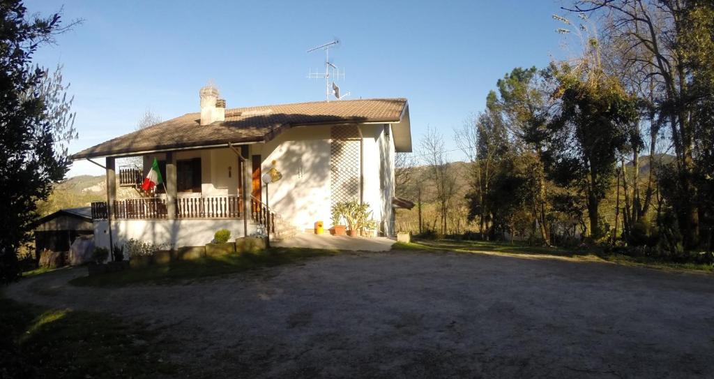 a small white house with a porch and a driveway at Il Prato in Predappio