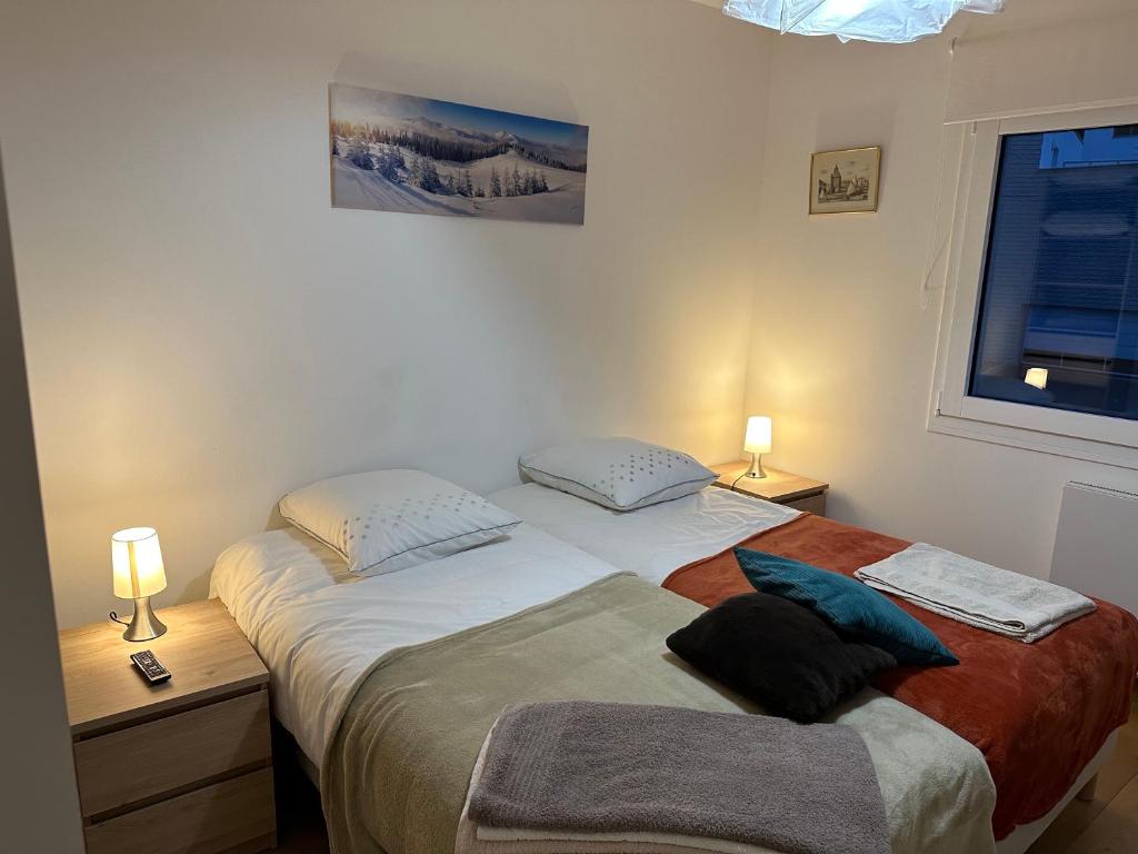 sypialnia z 2 łóżkami, 2 lampami i oknem w obiekcie Lac arte postale w Annecy
