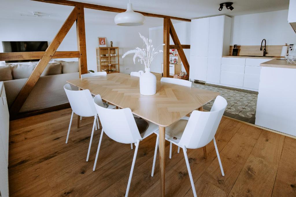 jadalnia z drewnianym stołem i białymi krzesłami w obiekcie Fritz im Glück w mieście Rietberg