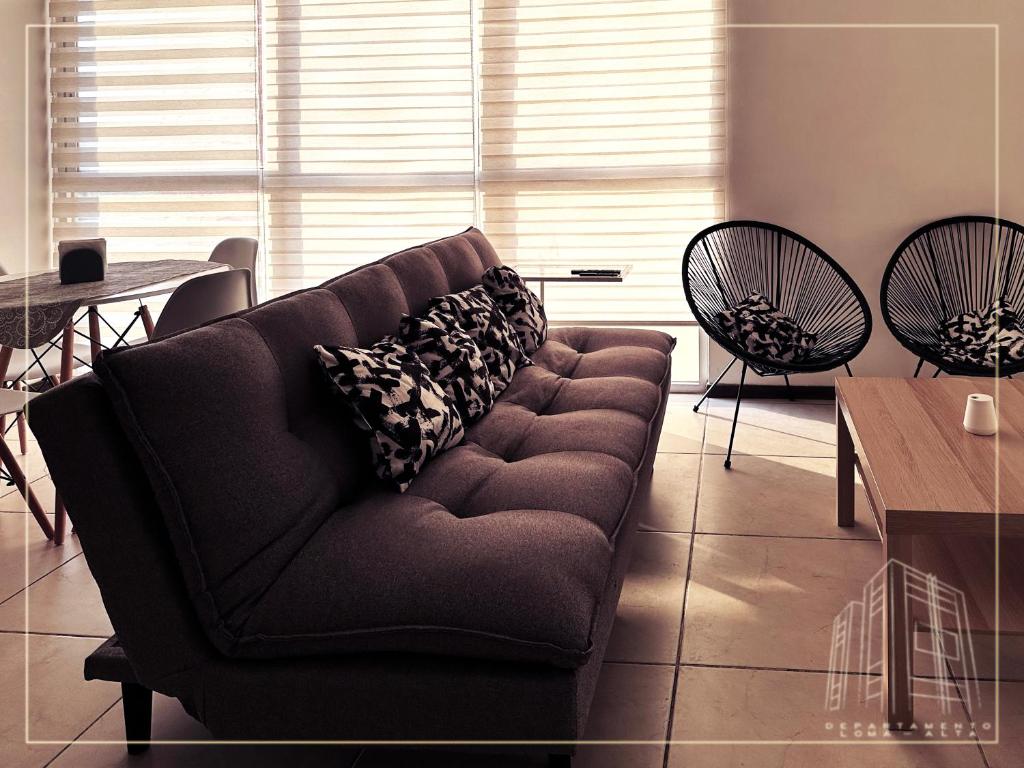 - un canapé dans le salon avec une table et des chaises dans l'établissement Departamento Loma-Alta, à Guadalajara