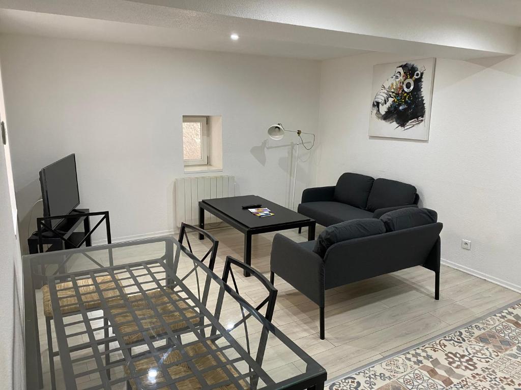 salon z kanapą i stołem w obiekcie Appartement 2ème étage 42m2 hyper centre ville / parking gratuit w mieście Riom