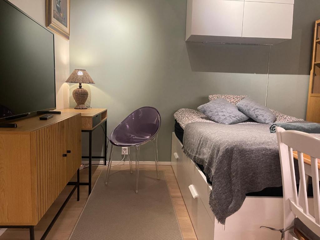 1 dormitorio con 1 cama y escritorio con TV en The Seaside Apartment Turku en Turku