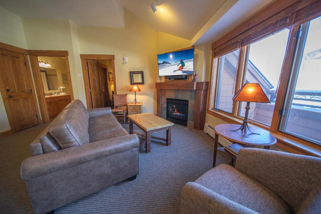 a living room with two couches and a fireplace at Springs 8910 in Keystone