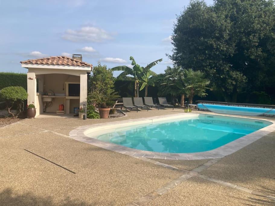 een zwembad in een tuin naast een huis bij Prignac en médoc-maison-6 pers-3ch-piscine chauffée 