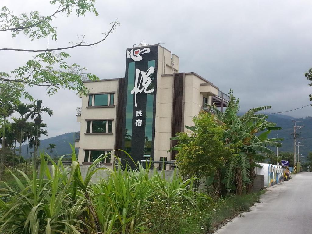 a building with a sign on the side of it at Xinyue B&B in Fenglin
