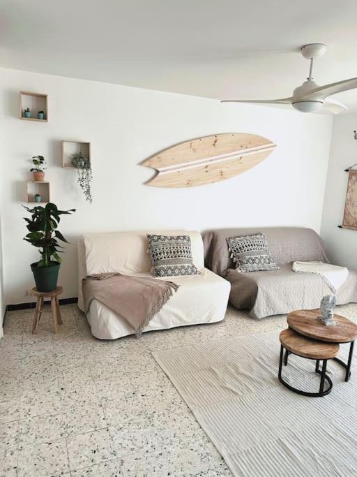 帕拉瓦萊弗洛特的住宿－Bel appartement 53m2 proche mer，客厅配有沙发和冲浪板。