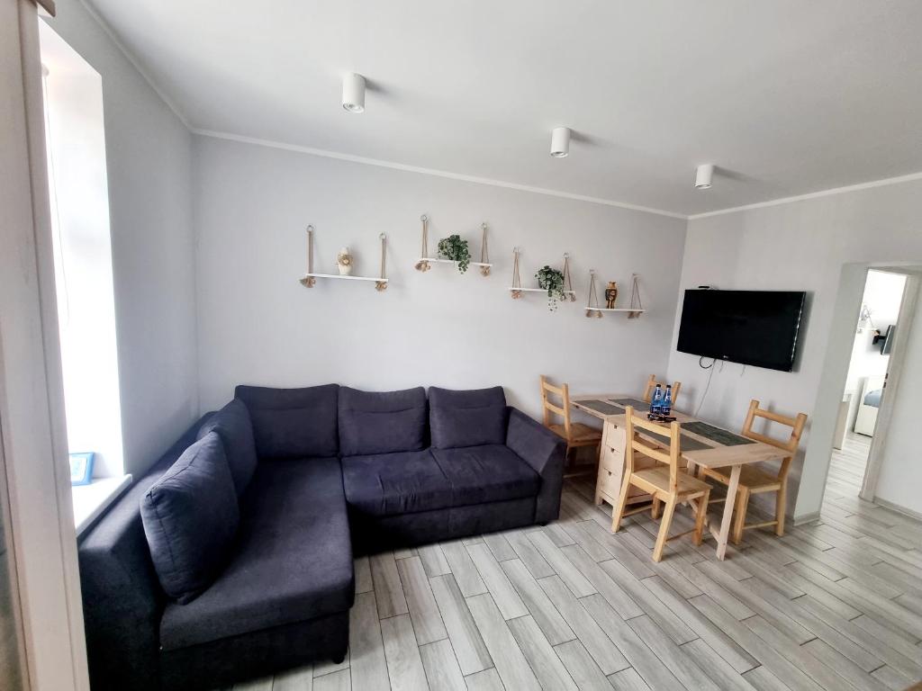 托倫的住宿－Apartament Katarzynka Toruń，客厅配有蓝色的沙发和桌子