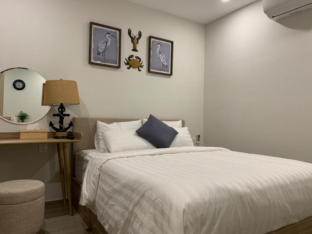a bedroom with a bed and a table with a mirror at A cozy condotel in Bai Sau(1 bed and 1 sofa bed) in Vung Tau