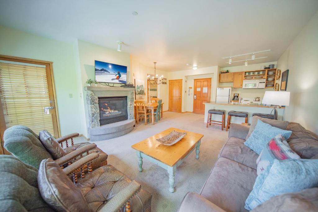 uma sala de estar com um sofá, uma mesa e uma lareira em Jack Pine 8015 em Keystone