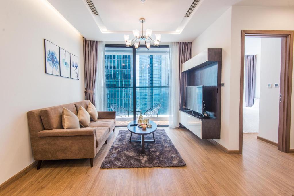 a living room with a couch and a tv and a table at 22housing Vinhomes Metropolis Hotel & Apartment in Hanoi