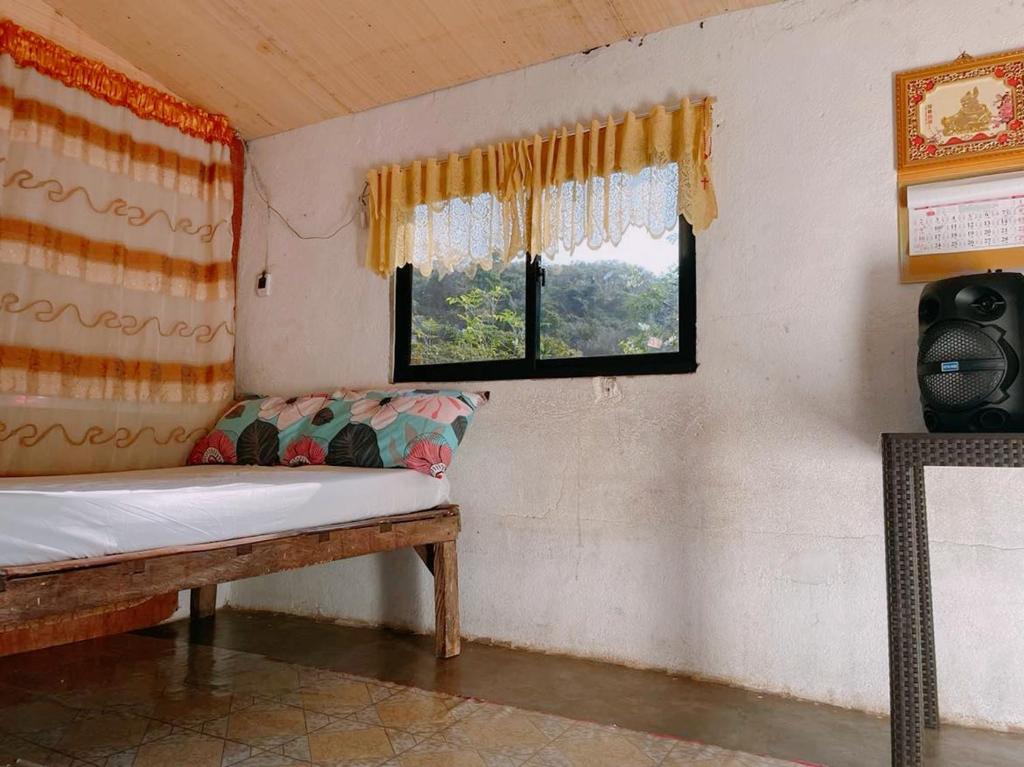 Zimmer mit einer Bank und einem Fenster in der Unterkunft Tina Transient Home in Cayluya