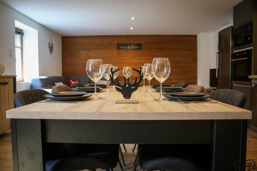 a dining room table with wine glasses on it at Gîte de la Ravanne in Ramonchamp