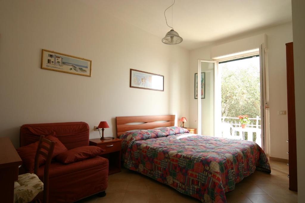 ein Schlafzimmer mit einem Bett, einem Stuhl und einem Fenster in der Unterkunft B&B La Baia Di Fiascherino citr01101sei-BEB-0011 in Tellaro