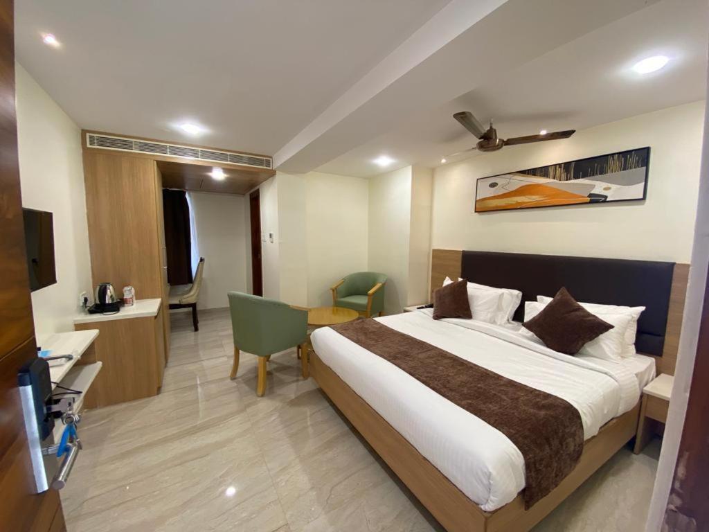 een hotelkamer met een groot bed en een bureau bij HOTEL TOUCHWOOD in Visakhapatnam