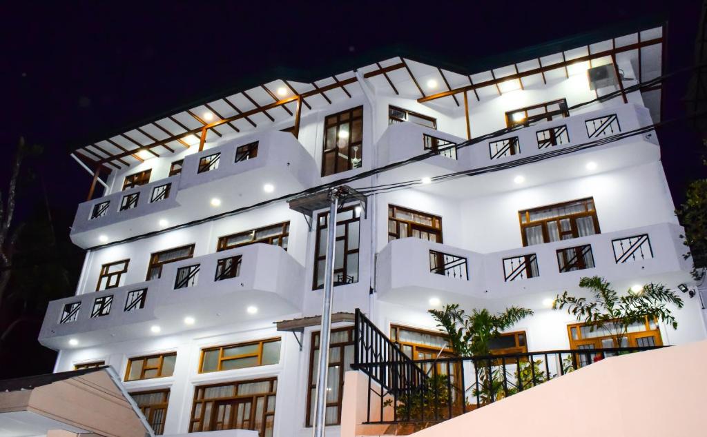 un edificio blanco con luces encendidas por la noche en SaRu Holiday Apartment - Upto 6 Guests, en Kandy