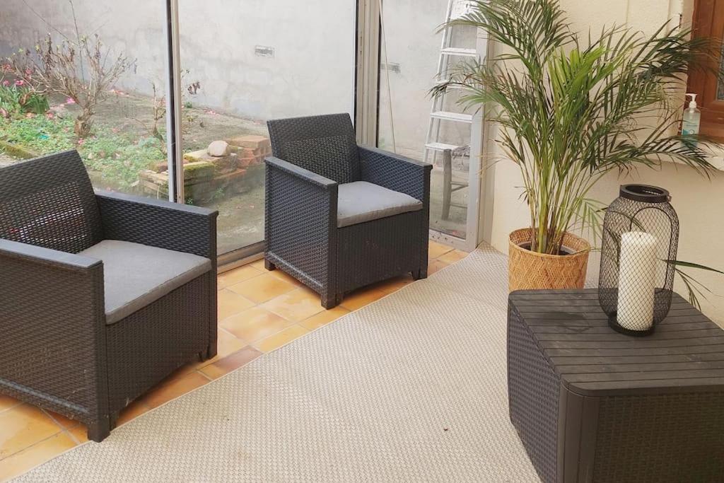 une chambre avec deux chaises, une table et une fenêtre dans l'établissement Maison au calme climatisée avec véranda, à Lapeyrouse-Fossat