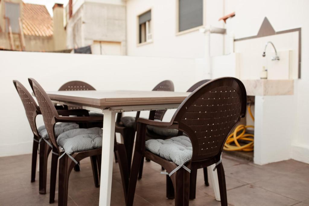 a table and chairs with a white table and a table and chairs at A Casa da Avó Cuca in Amiães de Baixo