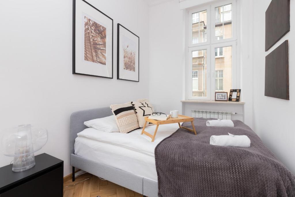 a white bedroom with a bed and a table at City Centre & Cosy Apartment by Renters in Gdańsk