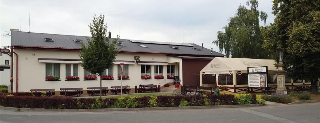 a building with tables and chairs in front of it at Na Rybníčku Bohutín in Bohutín