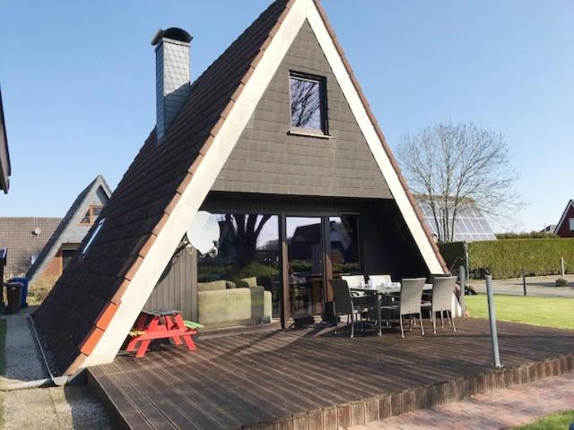 een huis met een dak met een tafel en stoelen bij 50159 Ferienhaus Catharina in Carolinensiel
