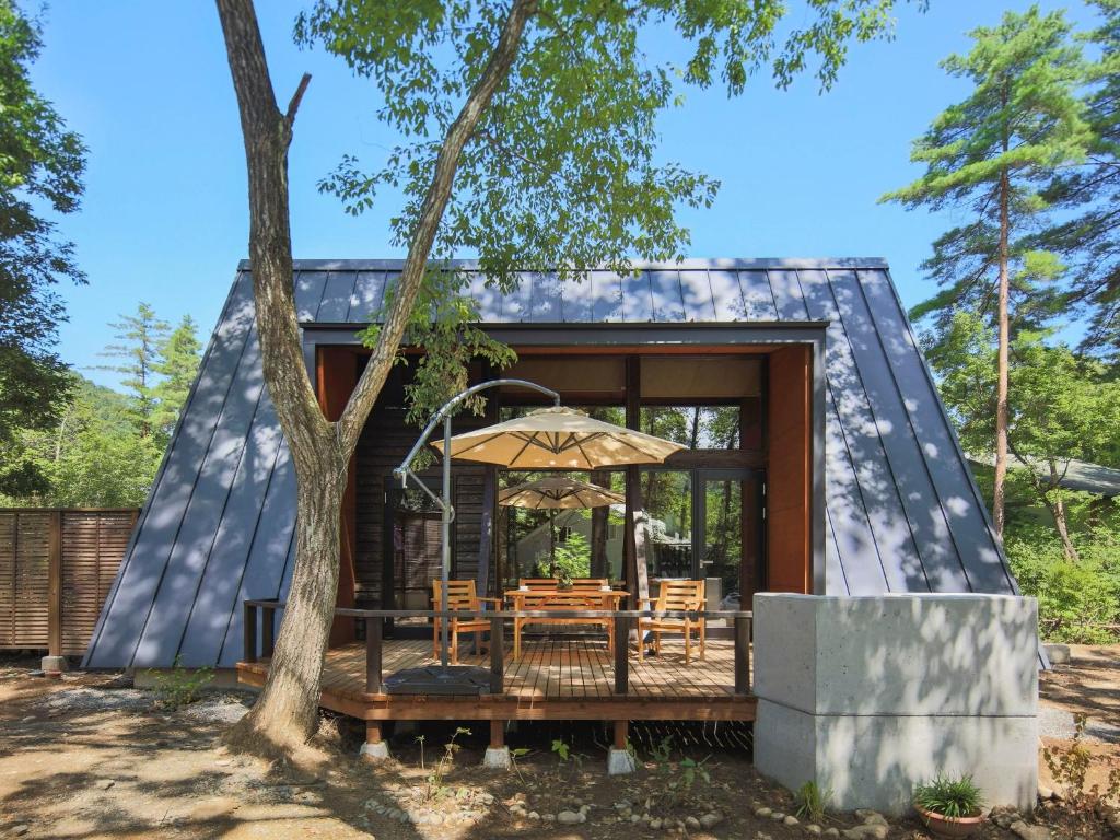 uma casa com um telhado preto e uma mesa com um guarda-chuva em Villa Yoshino - Vacation STAY 01568v em Azumino