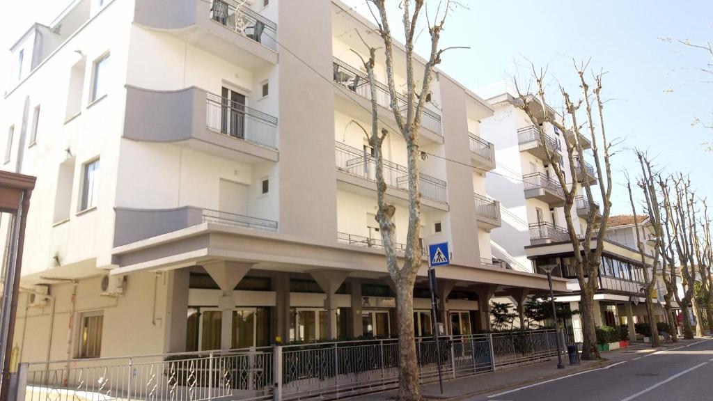 un edificio blanco con una señal de estacionamiento delante de él en Hotel Venezia Beach, en San Mauro a Mare