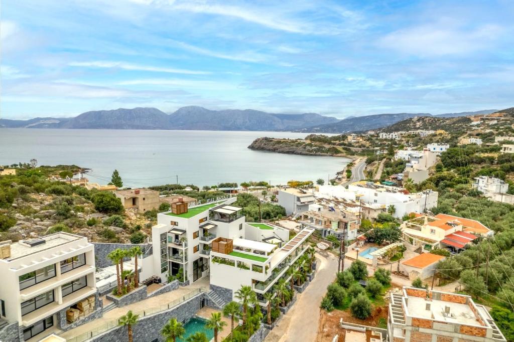 eine Luftansicht auf eine Stadt und einen Wasserkörper in der Unterkunft Lazar Lux Suites - Ammoudara in Agios Nikolaos