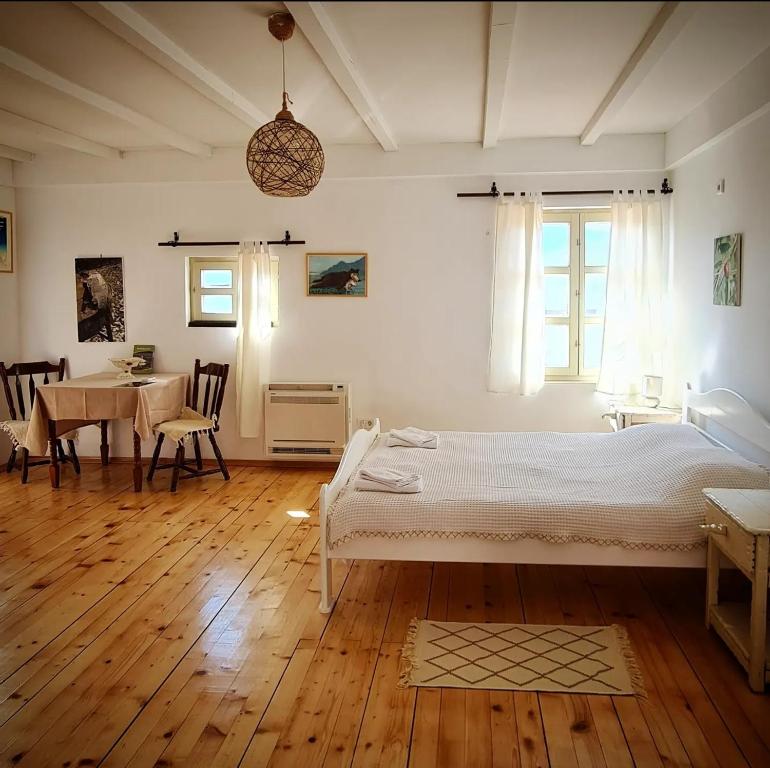 Schlafzimmer mit einem Bett und einem Tisch mit Stühlen in der Unterkunft Dembelija Rooms in Virpazar