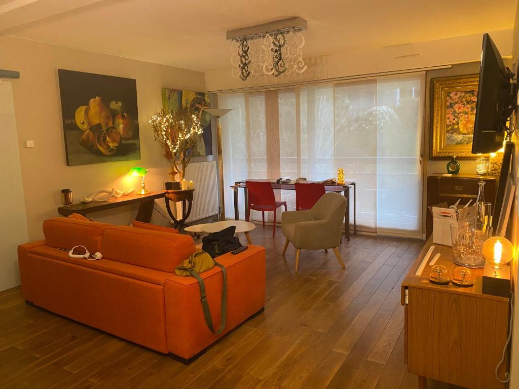 ヴァンヌにあるAppartement Monseigneurのリビングルーム(オレンジ色のソファ、テーブル付)