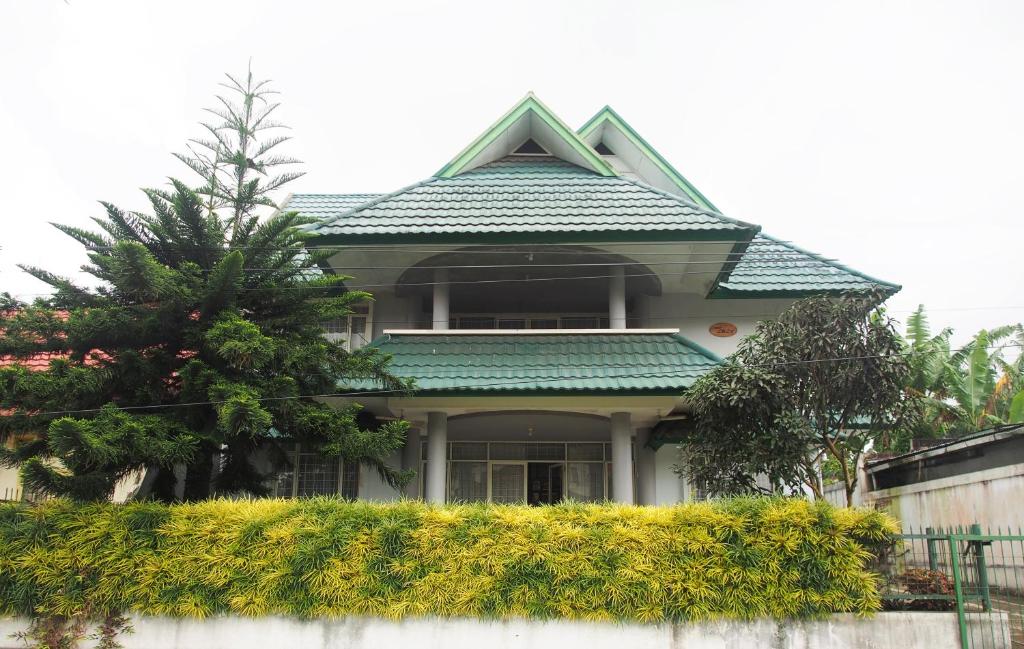una casa con un techo verde encima en Rumah Ijau - Halal Homestay, en Padangluar