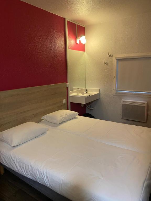 sypialnia z dużym białym łóżkiem i umywalką w obiekcie HOTEL F1 SAINT-LO w mieście Saint-Lô