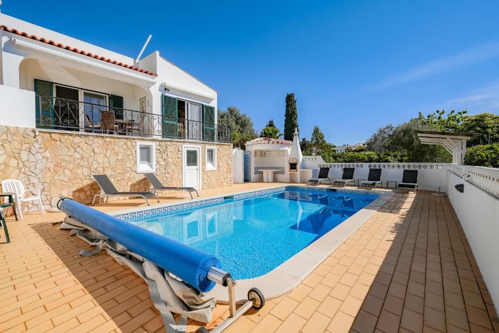 a villa with a swimming pool and a house at Casa Manjua in Carvoeiro