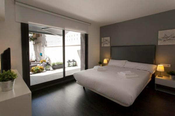 1 dormitorio con cama blanca y ventana grande en Parc Güell GF en Premia de Dalt